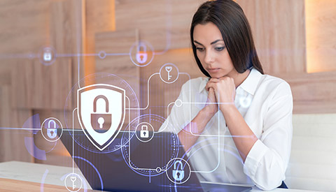 Women Sitting at Table with a Laptop with a Screen with Locks on It for Managed IT in Levittown, PA